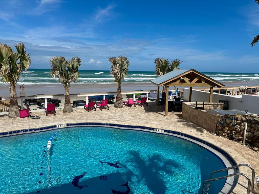 a swimming pool with the beach in the background at Flamingo Inn Beachfront - Daytona Beach in Daytona Beach