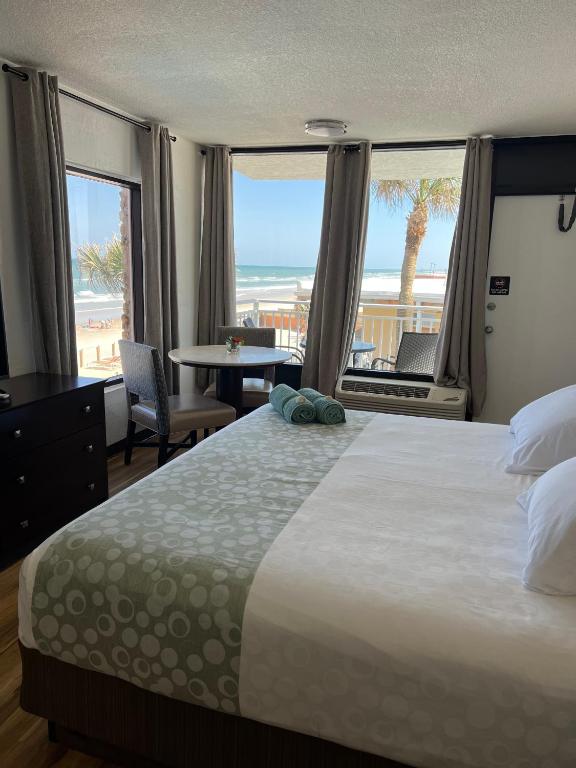 a bedroom with a bed and a view of the beach at Flamingo Inn Beachfront - Daytona Beach in Daytona Beach
