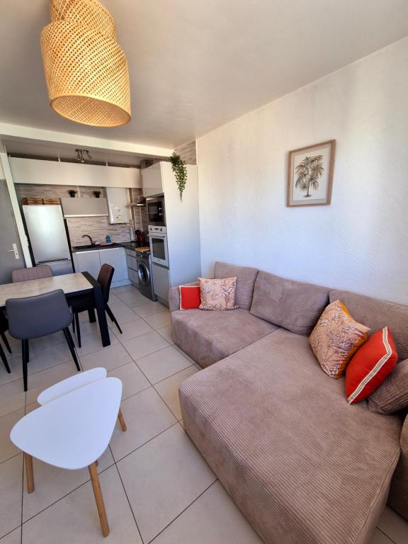 un salon avec un canapé et une table dans l'établissement Le Chap'Appart, T3, à Narbonne
