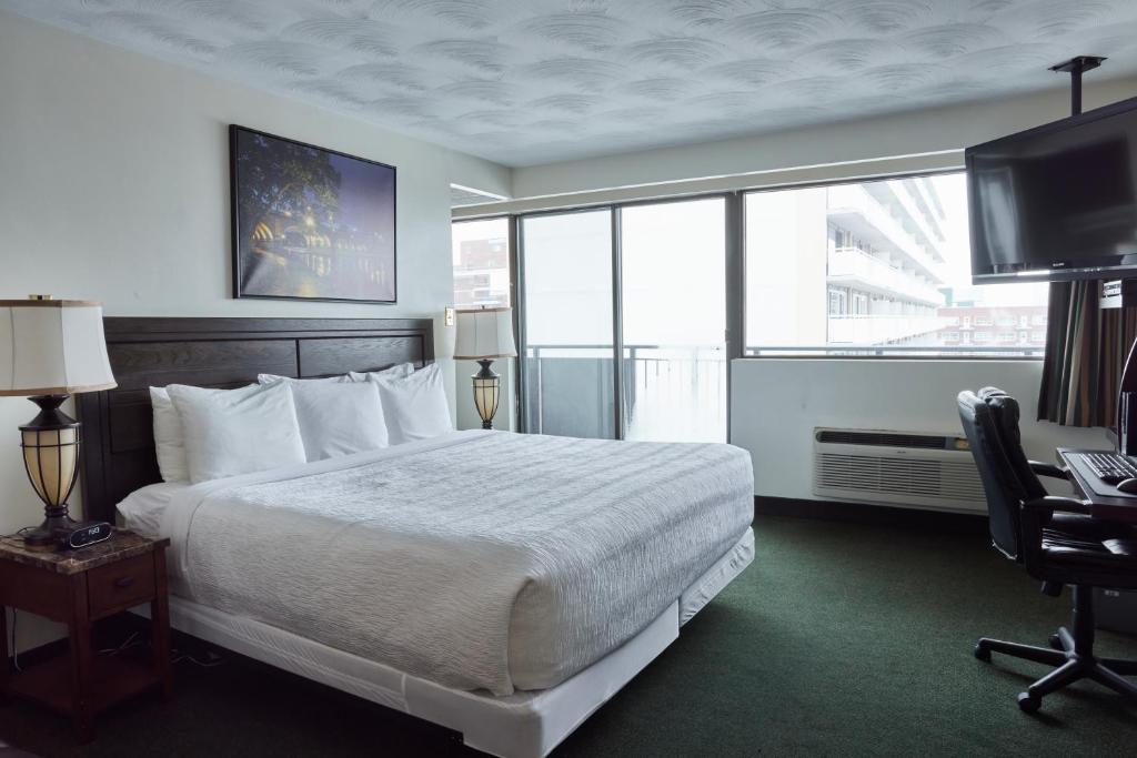 a hotel room with a bed and a desk and a television at The Business Inn in Ottawa