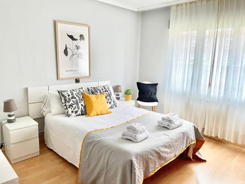 a bedroom with a bed with towels on it at Apartamento San Lázaro. in Oviedo