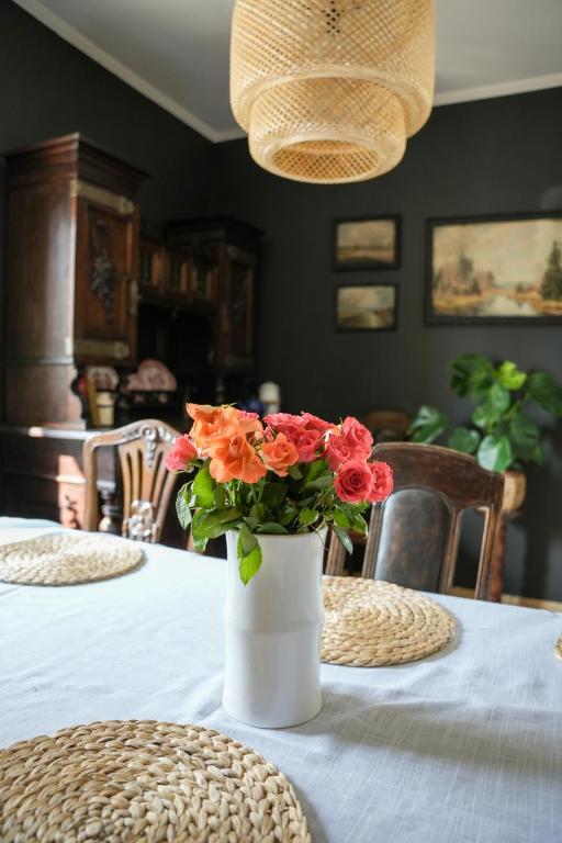 a vase with flowers on a table in a dining room at Relaks w boberkach Prywatna sala do Bilarda in Bobrowiec