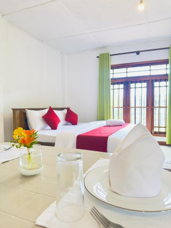 a hotel room with two beds and a table with a plate on it at Ceyonra Evermist Residence in Nuwara Eliya