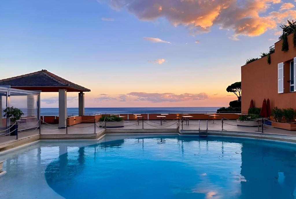 a swimming pool with a view of the ocean at Hotiday Arenzano Pineta in Arenzano