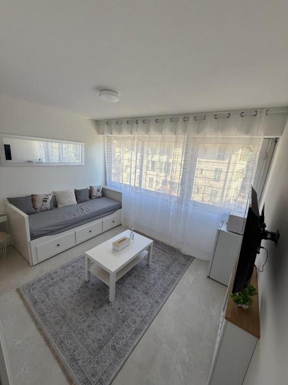 un salon avec un canapé et une table dans l'établissement Studio cosy entièrement équipé, à Nice