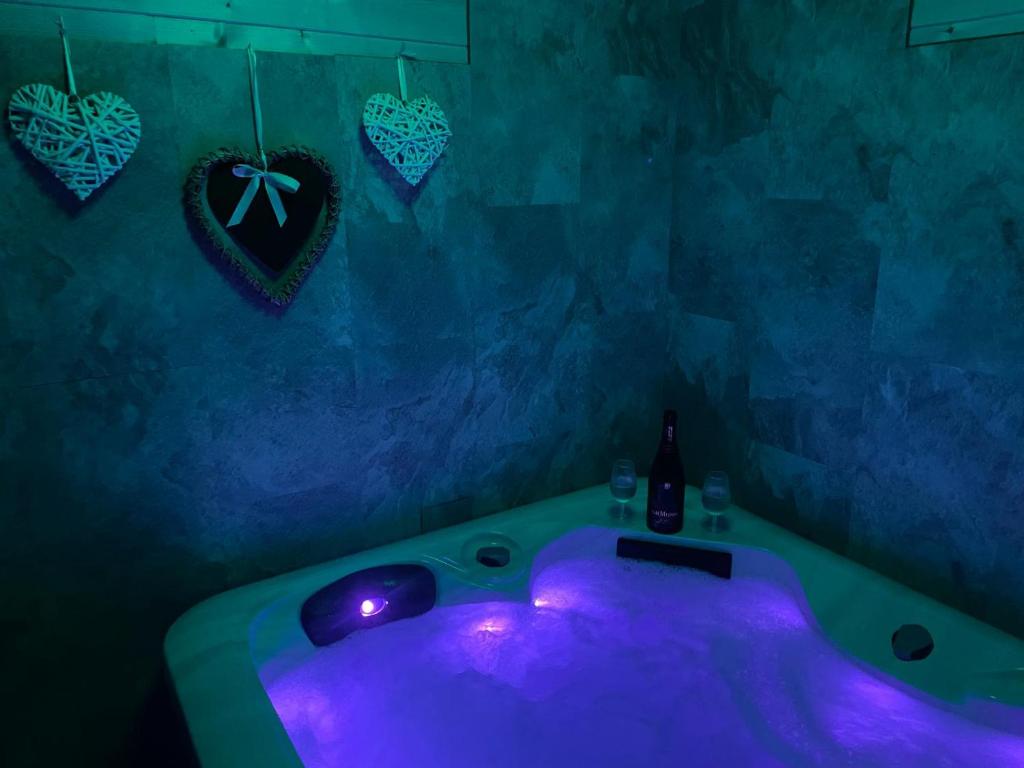 bañera púrpura con botella de vino y corazones en Haut Doubs Plaisir, SPA, en Chamesol