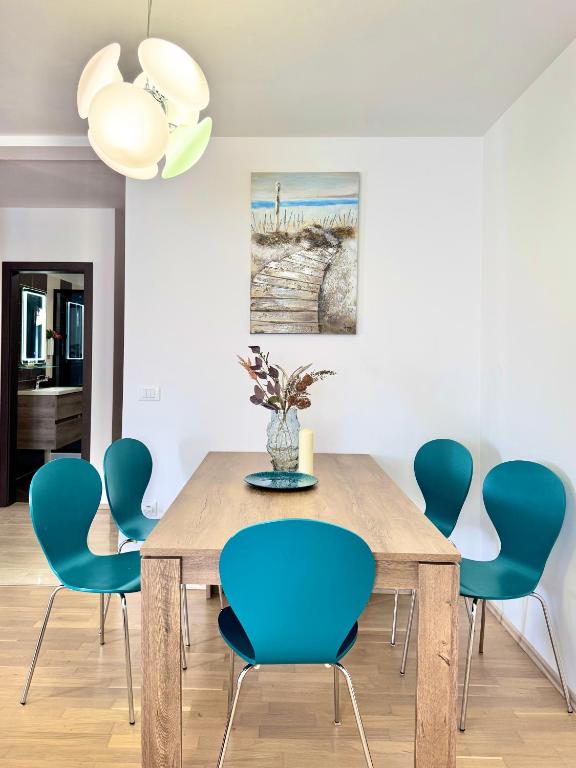a dining room with a wooden table and blue chairs at Apartments Terra Solaris in Medulin