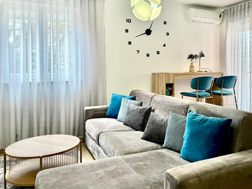 a living room with a couch and a clock on the wall at Apartments Terra Solaris in Medulin