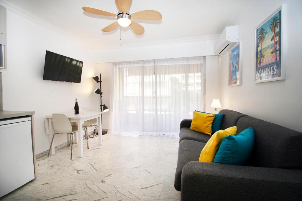 a living room with a couch and a table at Le Studio Cannois Standing Presta in Cannes