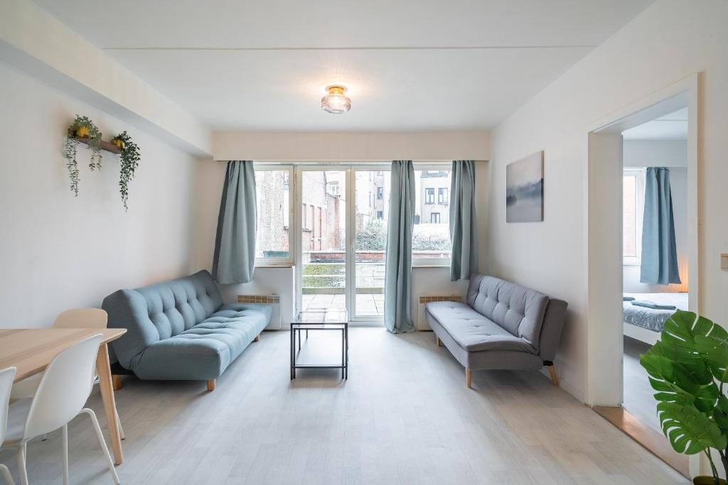 アントワープにあるBright and Central Antwerp Apartmentsの青いソファ2つとテーブルのあるリビングルーム