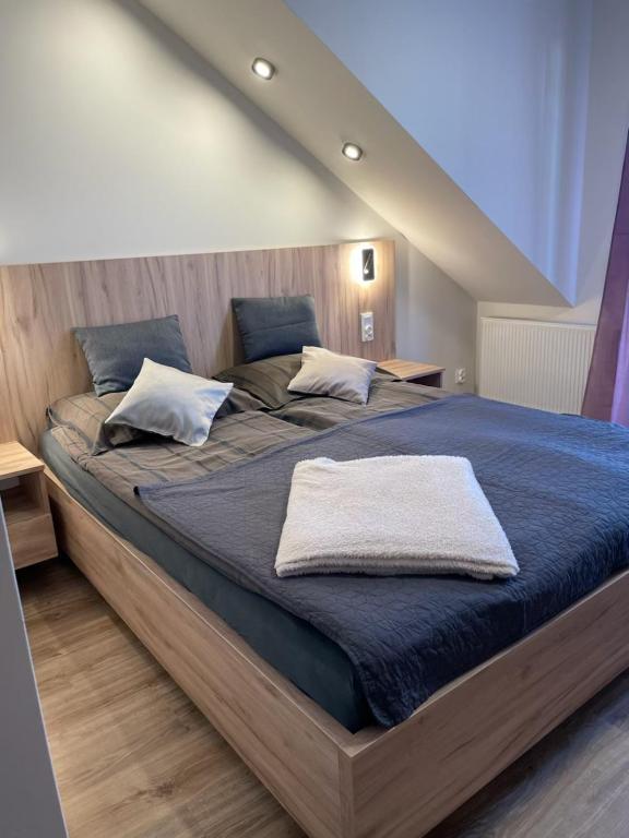 a bedroom with a large bed with blue sheets and pillows at Pokoje i apartamenty nad Letniskową in Mrzeżyno