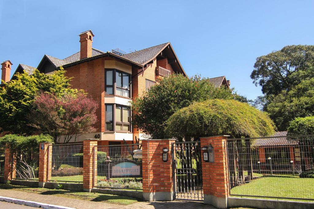 una casa de ladrillo con una puerta delante de ella en Condomínio Residencial Bugannvilias Flat en Gramado