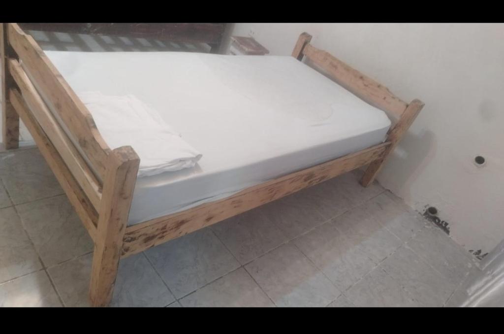 a small wooden bed in a corner of a room at Playa sol y arena in Puntarenas