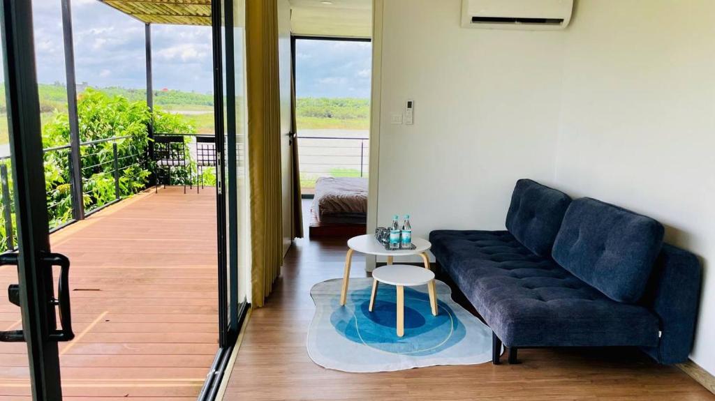 a living room with a couch and a table at The Lake House Retreat & Watersports in Tân Phú