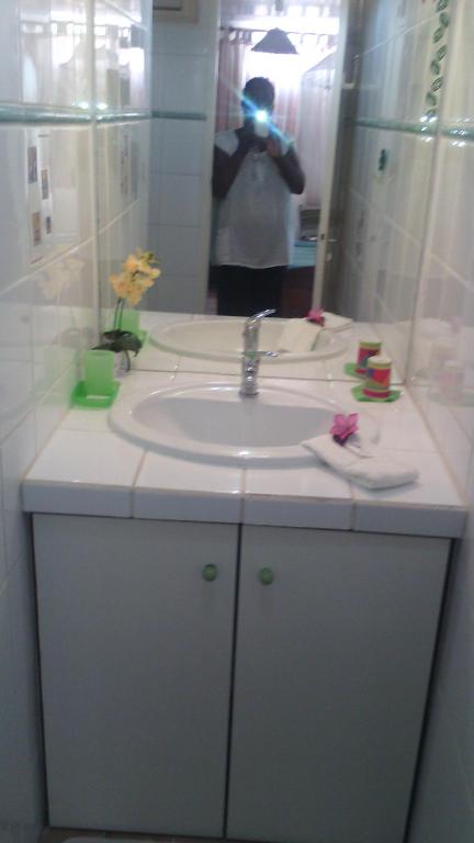 a person taking a picture of a bathroom sink at L'escapade in Sainte-Anne