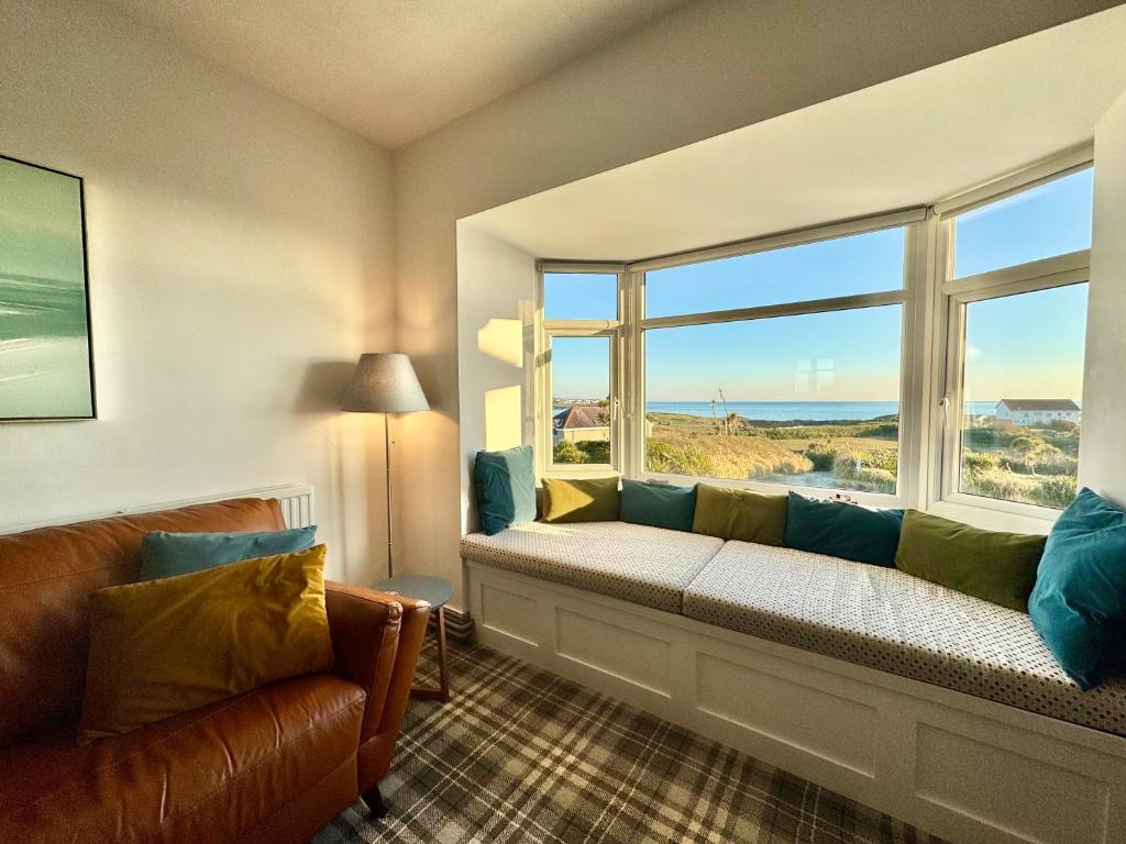 a living room with a couch and a large window at Lagoon View - Sea View- Pet Friendly - 2 Bed Apt - En-suite in Trearddur