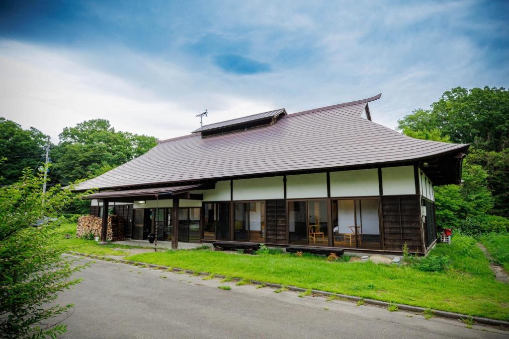 a house with a gambrel roof sitting on the grass at kominka Higurashi-an - Vacation STAY 18803 in To-katta