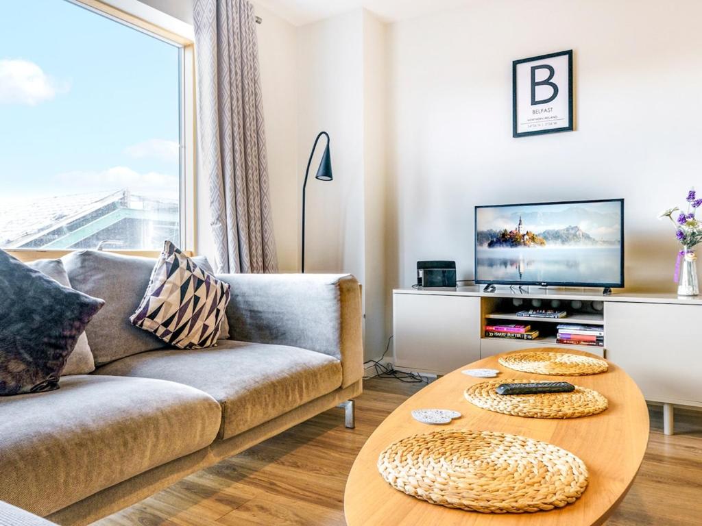 a living room with a couch and a table at Beautiful Loft Apartment City Centre in Belfast