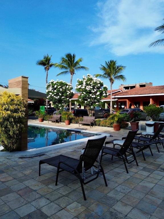un tavolo e sedie accanto a una piscina con palme di Hotel Pousada do Buriti a Barreirinhas