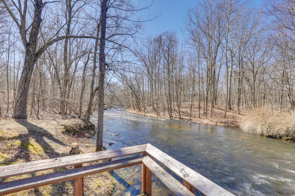 a wooden bridge over a river in a forest at Close to Trails Studio with Water Views in Wurtsboro