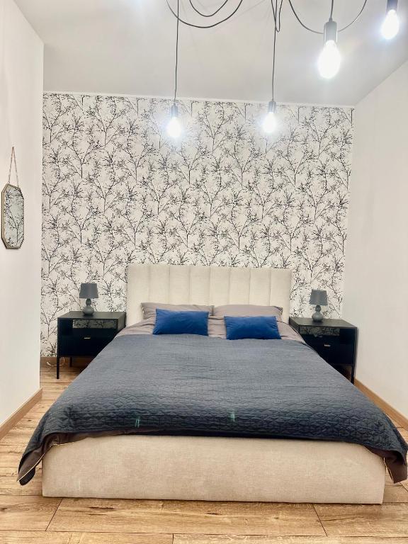 a bedroom with a large bed with blue pillows at Mieszkania od 32-55m, pełne wyposażenie, komfortowe warunki in Stanisławów Pierwszy