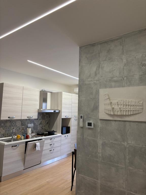 una cocina con armarios blancos y una pintura de un barco en la pared en roomestbb, en Roma