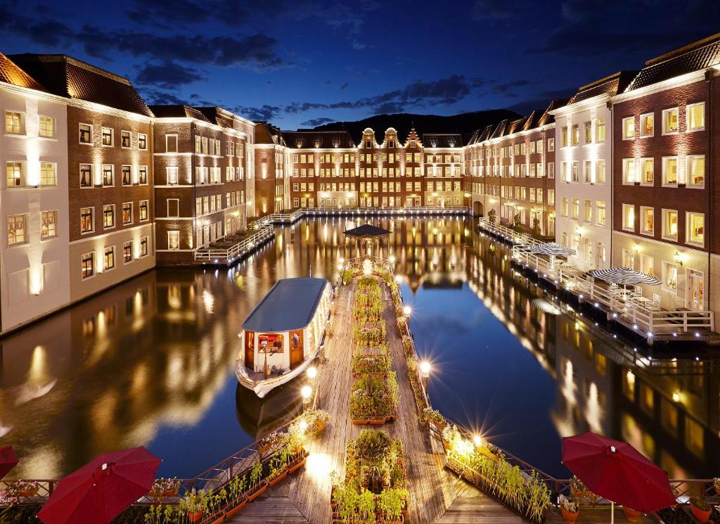 a large building with a canal at night at Hotel Europe Huis Ten Bosch in Sasebo