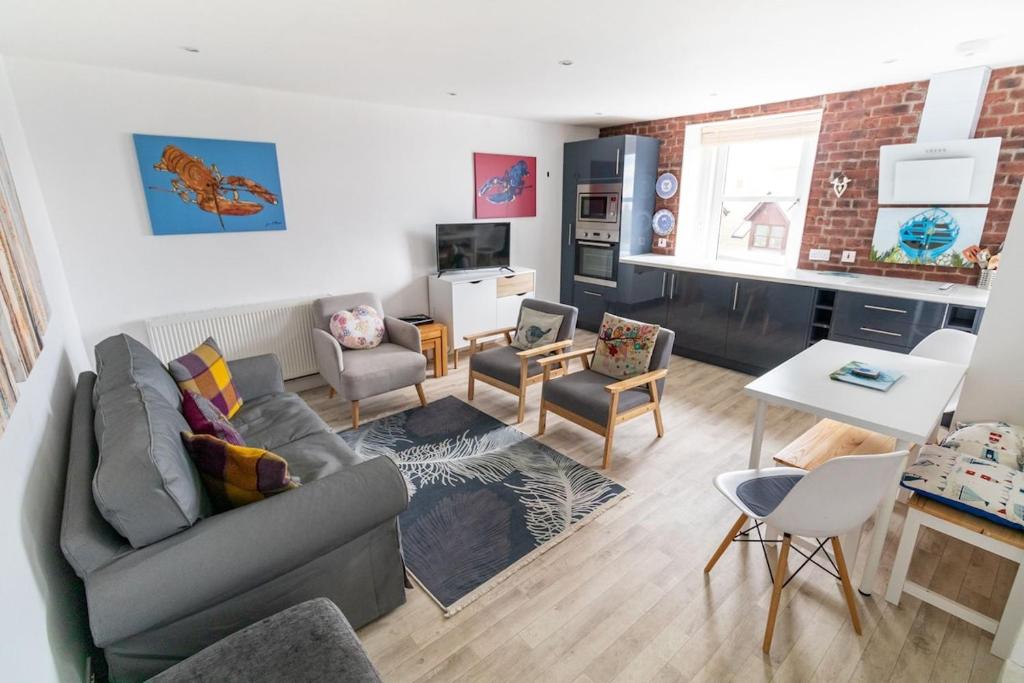 a living room with a couch and a table at Driftwood in Gourdon