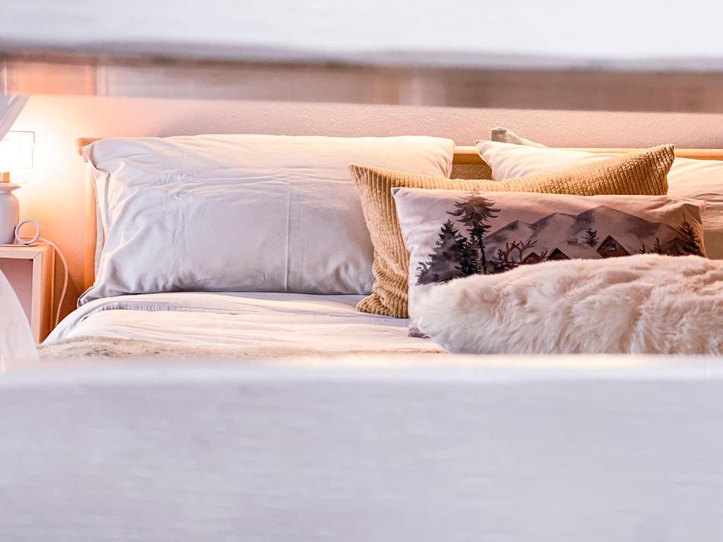 Una cama blanca con almohadas encima. en Dolci risvegli nella natura - Tuscan Dream, en Camaiore
