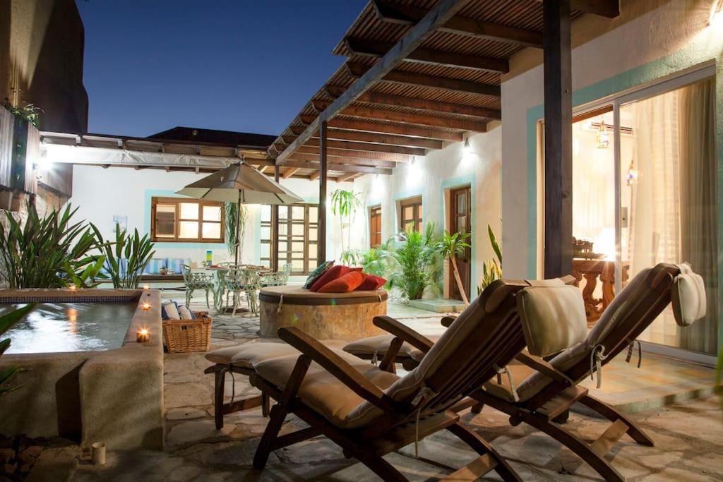 a patio with rocking chairs and a swimming pool at Casa Abuelita: An exquisite, historic La Paz home in La Paz