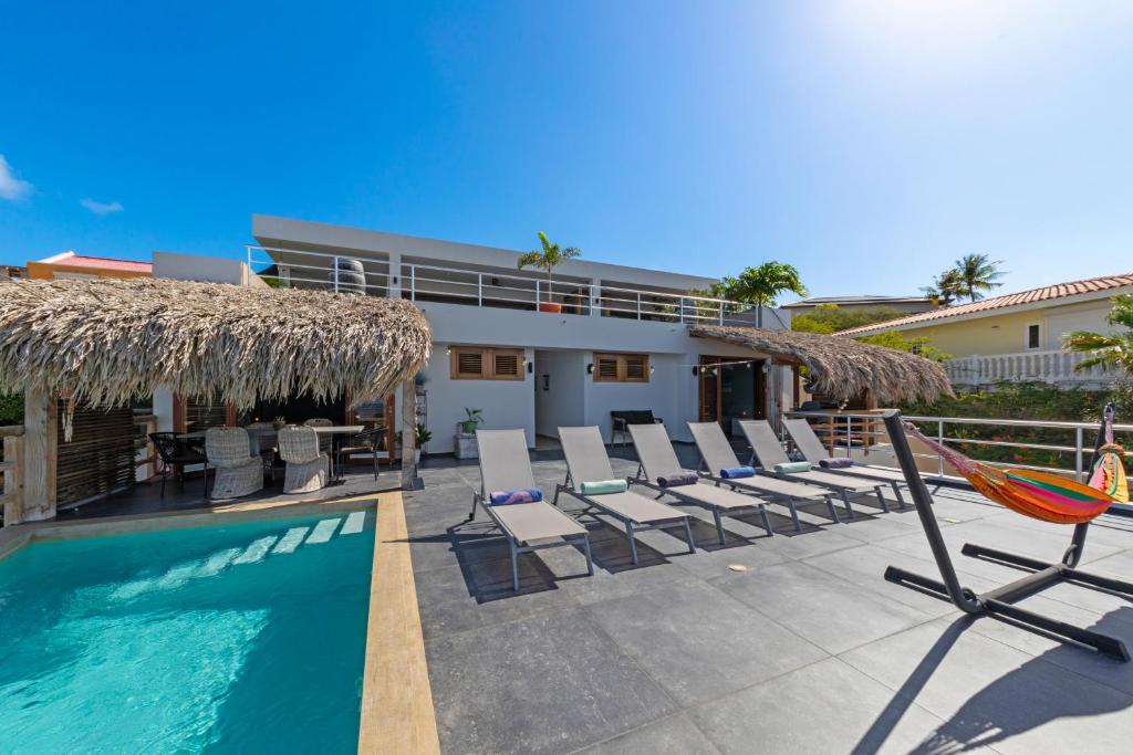 a resort with a swimming pool and chairs and a building at Villa Lahara with spectacular views in Dorp Soto