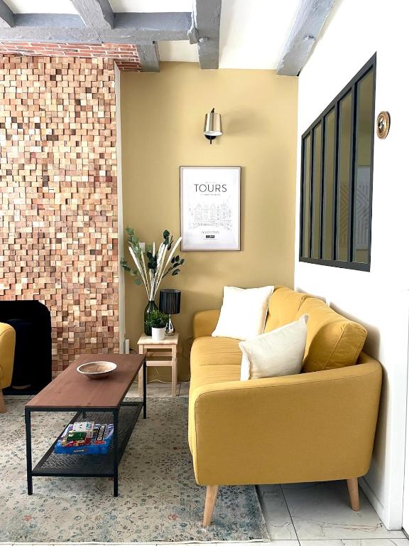 un salon avec un canapé jaune et une table dans l'établissement Douceur Tourangelle - Entre Loire et centre ville, à Tours