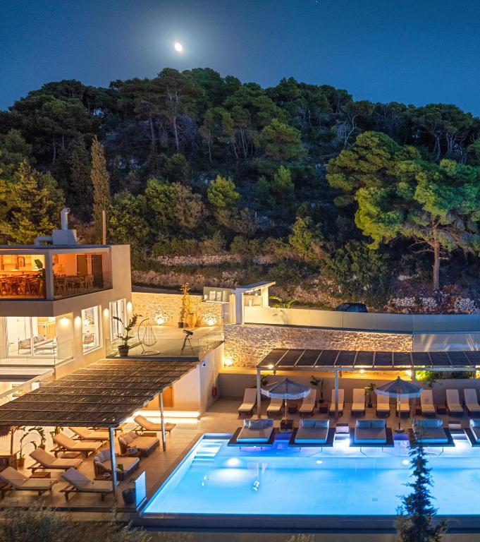 a villa with a swimming pool at night at Myzith Luxury Suites in Keri