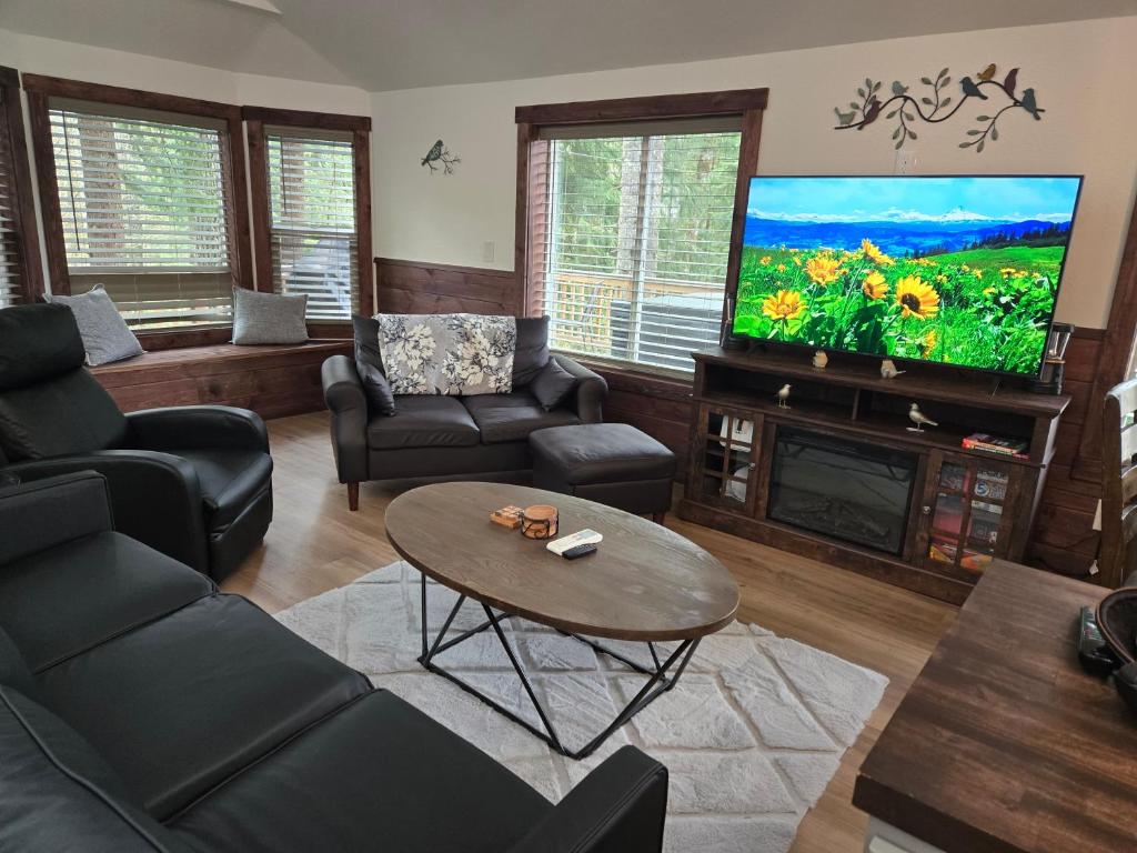 a living room with a tv and a couch and a table at Dovetail Den - Tranquil with Hot Tub and Air Conditioning in Ashford