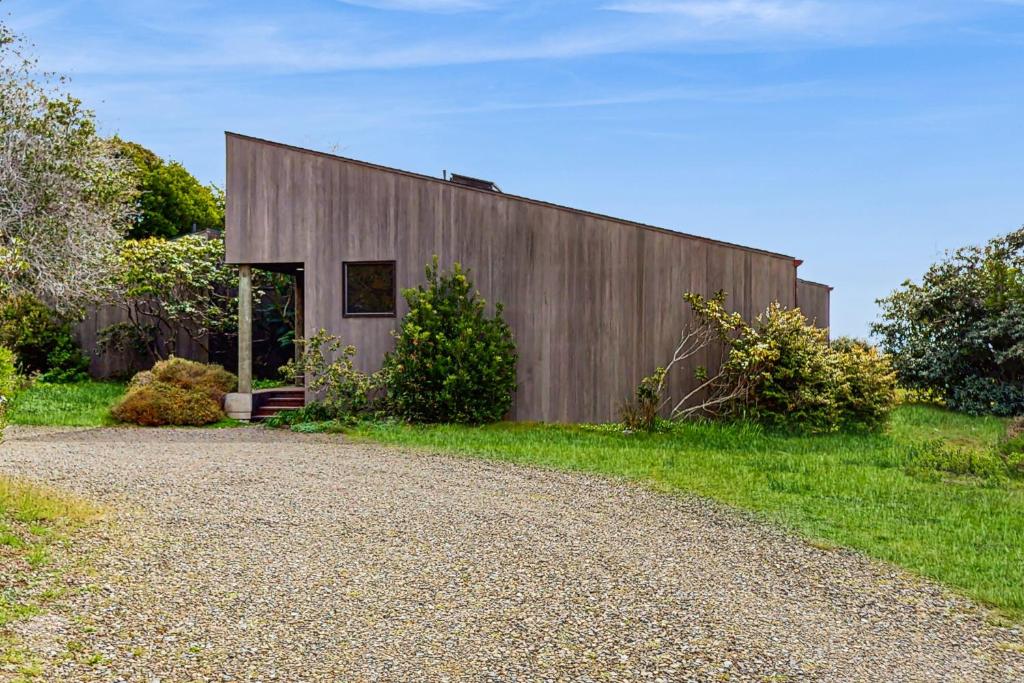 a wooden building with a gravel road next to it at Green Vale Getaway - 2 Bed 2 Bath Vacation home in Sea Ranch in Sea Ranch