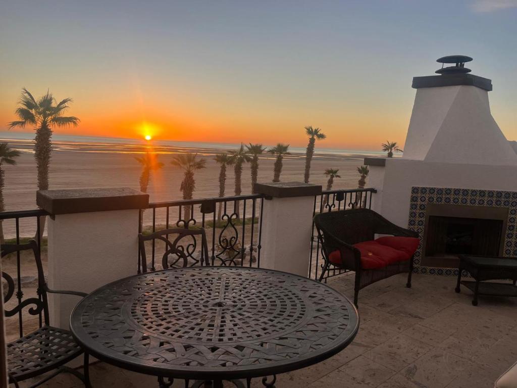 una mesa y sillas en un balcón con puesta de sol en El Dorado Ranch San Felipe Baja Beachfront Condo 763, en La Ponderosa