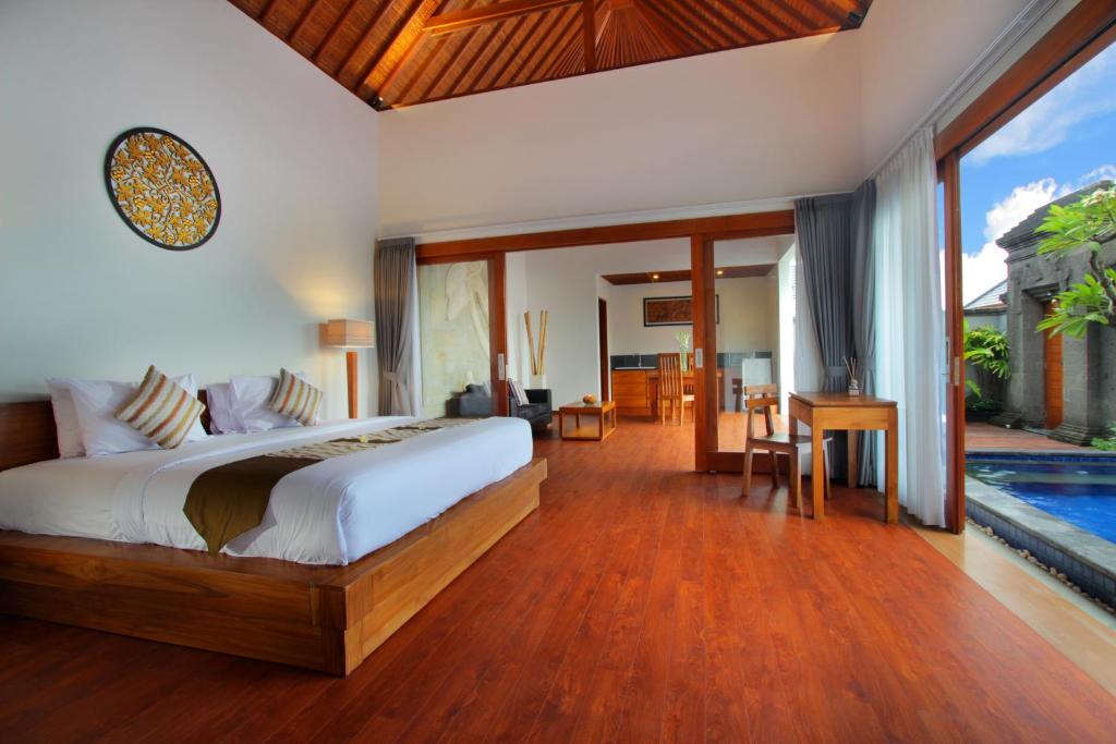 a bedroom with a bed and a swimming pool at Bali Nyuh Gading Villas in Seminyak