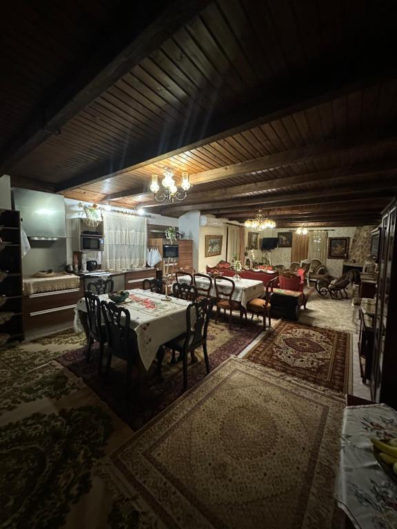 a dining room with a table and chairs and a kitchen at Archontiko Brides of Meteora in Kalabaka