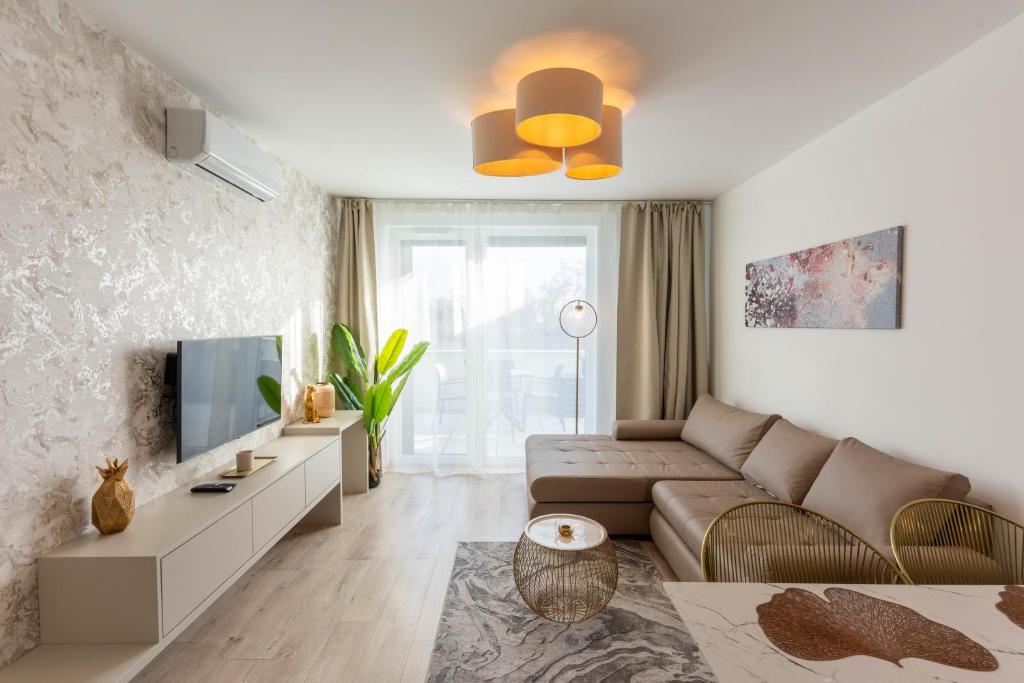 un soggiorno con un divano e una TV di Lakeside 101 Apartment a Fonyód