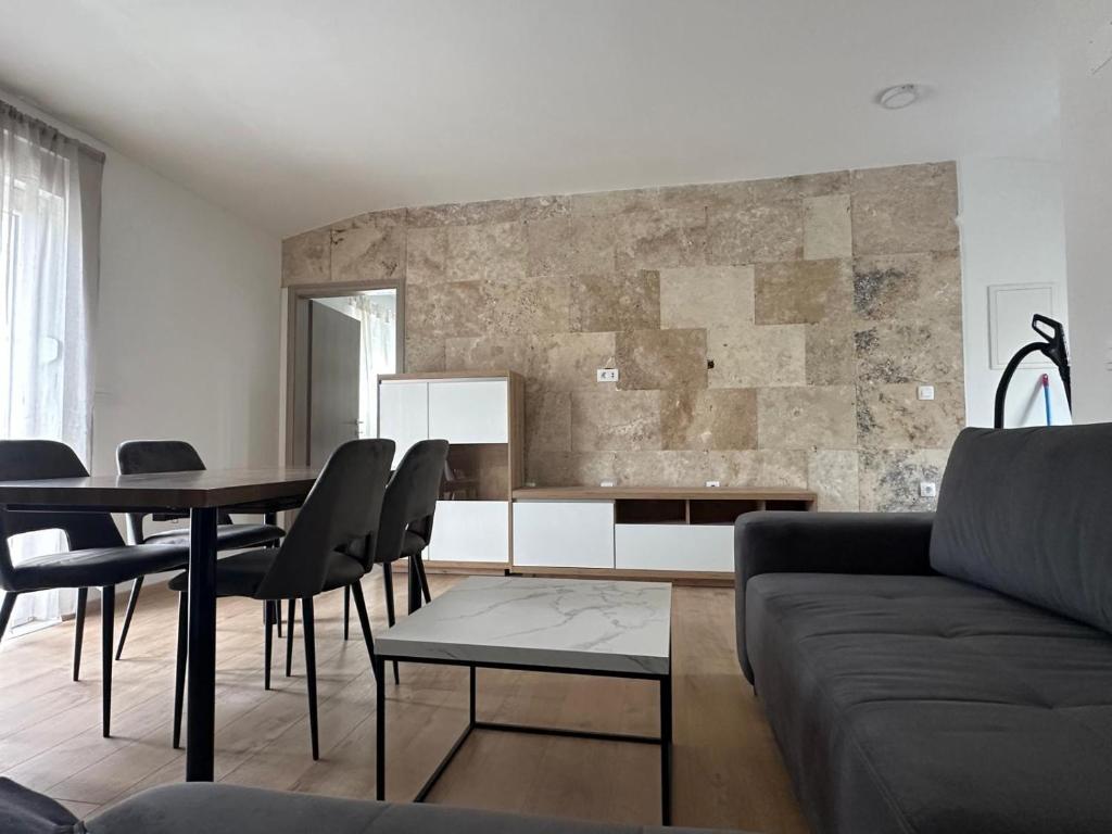 een woonkamer met een bank en een tafel bij Apartman Little Dream in Split