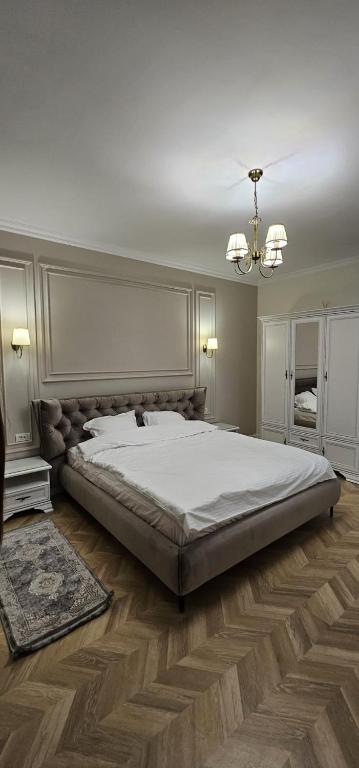 a bedroom with a large bed and a chandelier at Sonne by BED-Stage in Braşov
