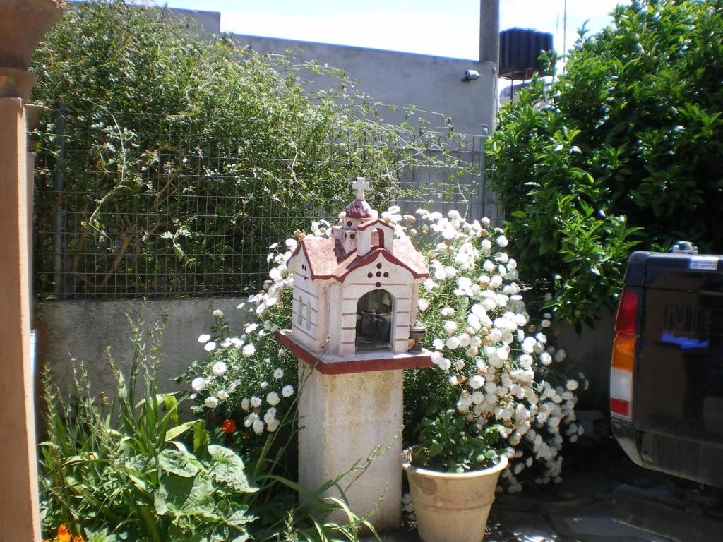 a small bird house in a garden with flowers at Xenos Apartments in Keratokampos