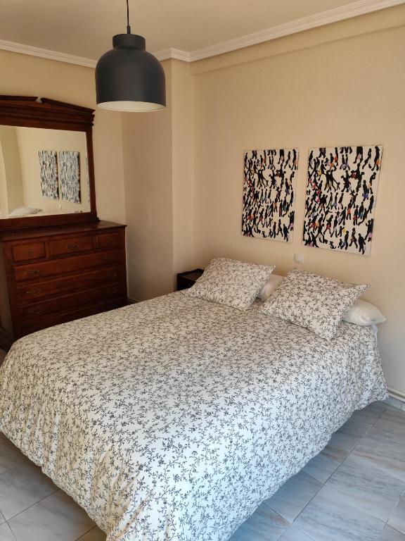 a bedroom with a bed and two paintings on the wall at Casa Rural Pesquera de Duero in Pesquera de Duero