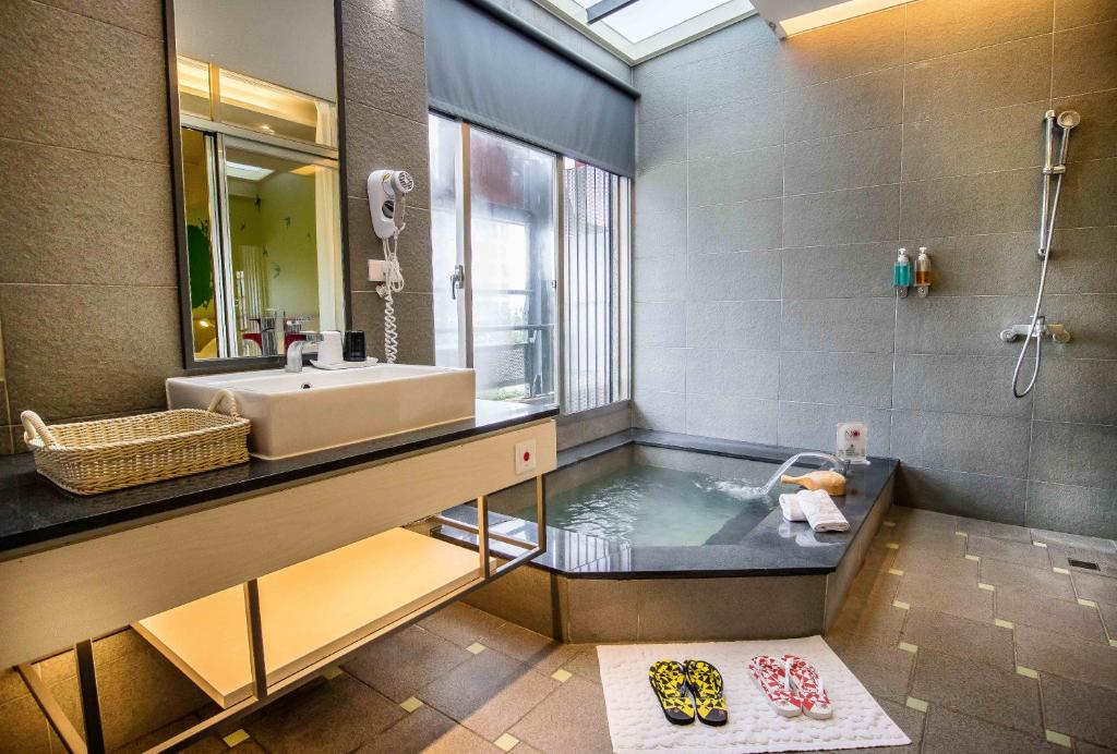 礁溪鄉的住宿－礁溪九號溫泉旅店，浴室配有盥洗盆和浴缸。