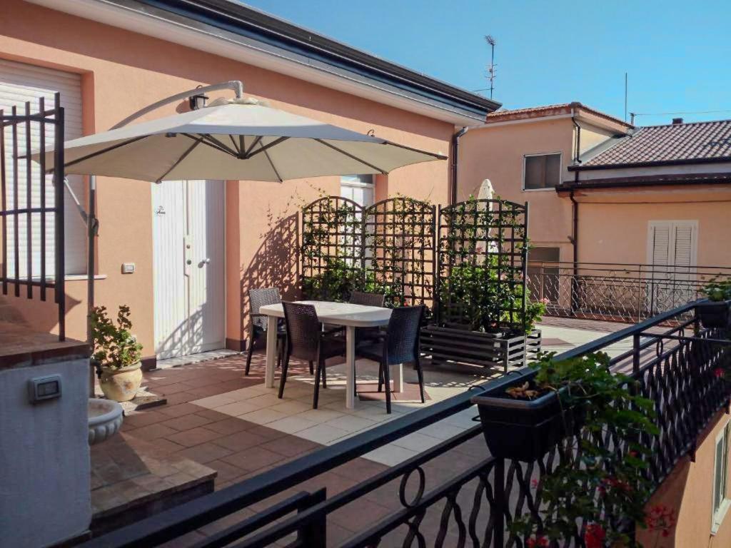 patio ze stołem i parasolem na balkonie w obiekcie Casa Vacanze Anna & Giulia w mieście Torchiara