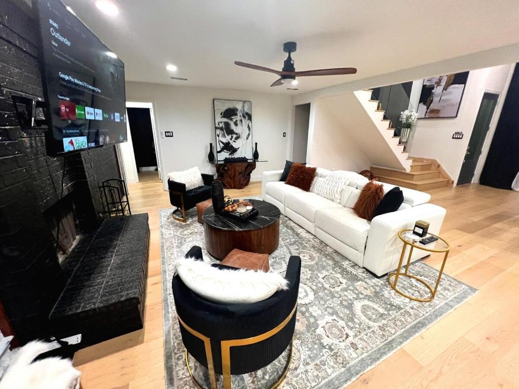 a living room with white couches and a fireplace at Luxury Home w Pool, Open Kitchen, Poker Room & More in Dallas