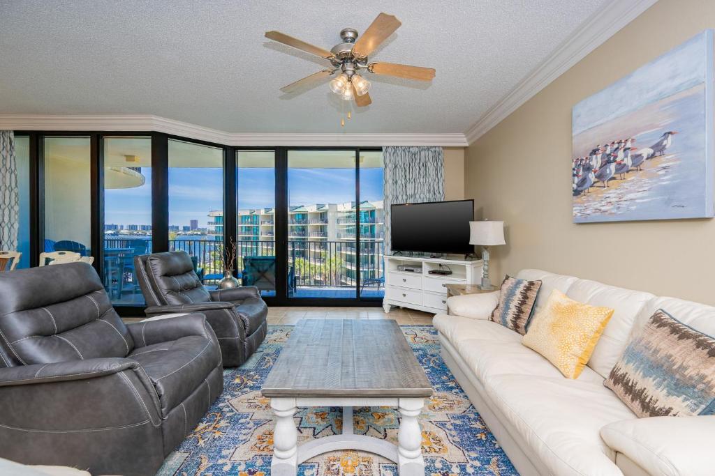 a living room with a couch and a tv at Phoenix on the Bay 1429 condo in Orange Beach