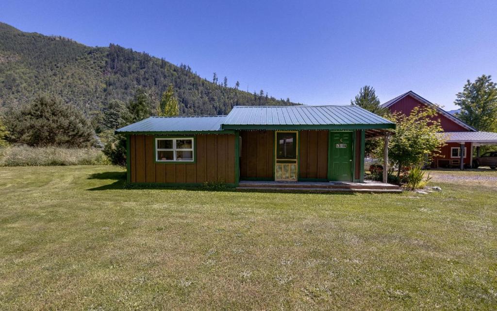 a small house with a green door in a yard at Making lasting memories while enjoying this unique glamping experience in Maple Falls