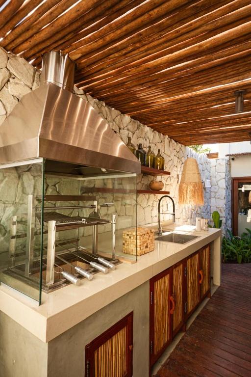 a kitchen with a counter with a sink and a stove at Caraíva Villas de Jardel - Casa Principal in Caraíva