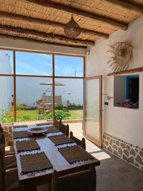 ein Esszimmer mit einem Tisch und einem großen Fenster in der Unterkunft Octopus house in Wassane